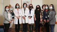Eight members of the cystic fibrosis care team stand together where medical masks